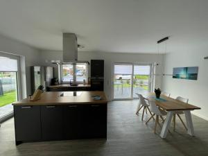 cocina y comedor con mesa, mesa y sillas en Ferienhaus Urlaubshafen, en Bremerhaven