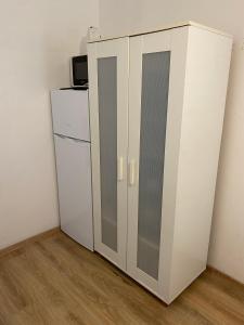 a white cabinet in a room with a refrigerator at Cozy Jabotinsky Studio in Ashdod in Ashdod