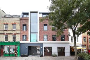 un grand bâtiment en briques avec une façade verte et blanche dans l'établissement Battersea Luxury Apartment, Private, Independent Entrance, Central, à Londres