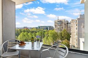 - Balcón con mesa y sillas y vistas a la ciudad en Unirii Plaza Apartment, en Bucarest