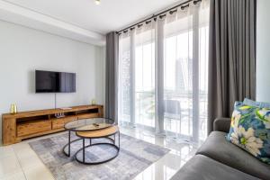 a living room with a couch and a tv at AlimamaSpaces The Moksit Suite Ellipse in Midrand