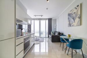 a kitchen and living room with a table and chairs at AlimamaSpaces The Moksit Suite Ellipse in Midrand