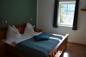 una camera da letto con un letto con una coperta blu e una finestra di Ferienstadl - Hammerau a Göstling an der Ybbs