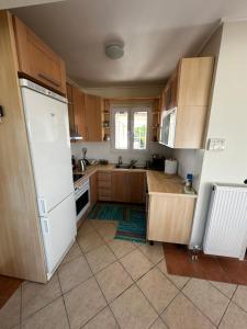 a kitchen with wooden cabinets and a white refrigerator at Beachfront Villa Tranquility in Longós