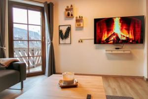 a living room with a fire on the wall at Jacuzzi, Sauna, Garten, Terrasse, Grill, 6 Personen, Moselstaustufe, Netflix, Sky, Smart TV in Neef