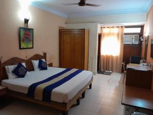 a bedroom with a bed and a desk and a window at HOTEL CITADEL in Vasco Da Gama