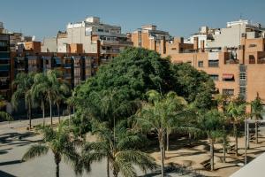 un grupo de palmeras frente a una ciudad en Europa Apartments en Hospitalet de Llobregat