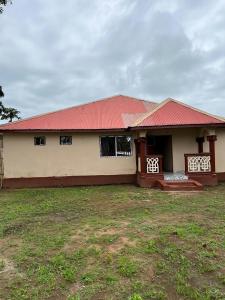 una casa con techo rojo y patio en Yogi Home Stay Near Freetown Airport en Freetown