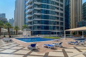 uma piscina com espreguiçadeiras e um grande edifício em Frank Porter - Bay Central em Dubai