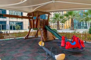 a playground with a slide in a building with palm trees at Frank Porter - Bay Central in Dubai