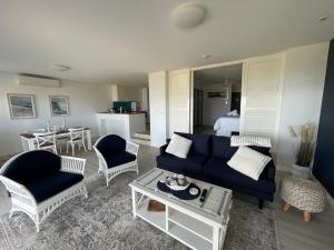 a living room with a blue couch and chairs at Beachside Villa 7.1 in Mandurah