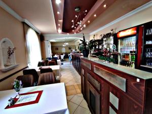 Átrium Hotel Harkány في هاركاني: مطعم به بار به طاولات وكراسي