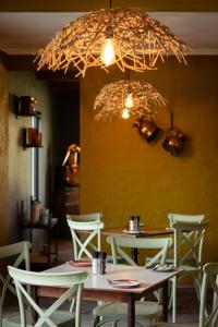 ein Esszimmer mit Tischen und Stühlen und einem Kronleuchter in der Unterkunft Blaauwklippen Manor by NEWMARK in Stellenbosch