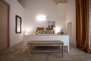 a room with a bed with a table and a bench at IMMA APULIA APARTMENTS in Bari