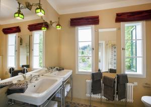 a bathroom with two sinks and two mirrors at Garden Cottage der Villa Liechtenstein in Altaussee