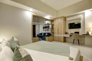 ein Schlafzimmer mit einem Bett und einem Schreibtisch in einem Zimmer in der Unterkunft Saltstayz Premier Executive Serviced Apartment - Golf Course Extension Road in Gurgaon