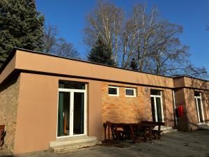 een klein bakstenen gebouw met een groep tafels bij Öreg-tó Youth Hostel in Tata