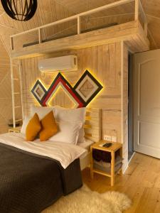 sypialnia z łóżkiem z drewnianą ścianą w obiekcie Honey dome w mieście Vizhenka
