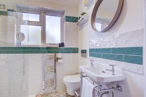 a bathroom with a sink and a toilet and a mirror at 132 Qweens Stay in Southend-on-Sea