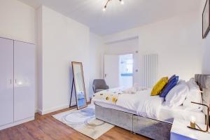 a white bedroom with a bed and a mirror at 132 Qweens Stay in Southend-on-Sea