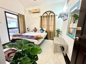 - une chambre avec 2 lits dans une pièce ornée de plantes dans l'établissement GR Stays - Duplex 3bhk Villa With Pool Arpora I Baga Beach 5 mins, à Arpora