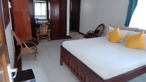 a bedroom with a bed with yellow pillows at Vera comfort in Mombasa