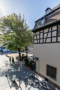 un bâtiment avec un arbre à côté d'une rue dans l'établissement Petit arc en ciel, à Strasbourg