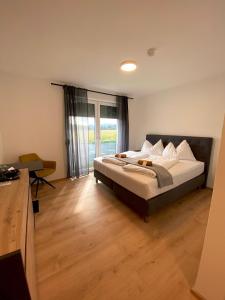 1 dormitorio con cama grande y ventana grande en To Be, en Sankt Andrä