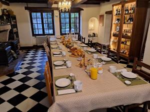 a long table in a room with a checkered floor at La Rossignolerie - Cabane aux oiseaux in Chouzy-sur-Cisse
