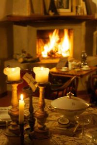 a table with candles and a fireplace in a living room at Residenza Buggiano Antica B&B - Charme Apartment in Tuscany in Borgo a Buggiano