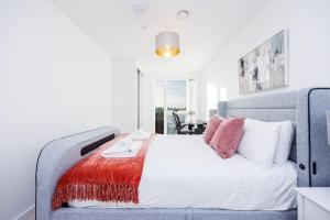 a bedroom with a large bed with red and white pillows at Offers Available - 2 Bed Apartment Business Relocation London City Airport in London