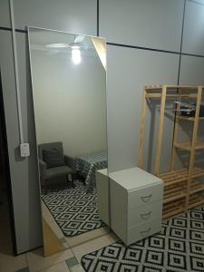um quarto com um espelho, uma cómoda e uma cadeira em dormitorio 4 solteiro luxuoso a 2 km de alphaville em Barueri