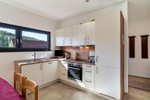 a kitchen with white cabinets and a window at Ferienwohnung Rennbachtal in Bad Herrenalb