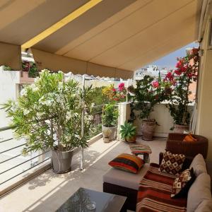 a balcony with a couch and some potted plants at Athens Central Apartment 2 mins to metro in Athens