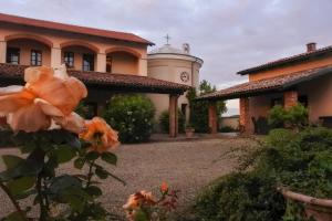 ein Gebäude mit einem Uhrturm und einer Blume in der Unterkunft Azienda Agricola Tenuta del Barone in Calliano