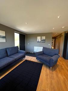 a living room with two blue couches and a rug at Countryside Chalet near Glasgow in Glasgow