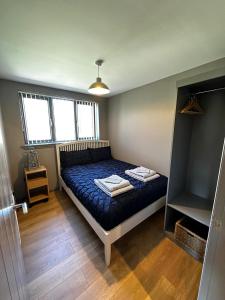 a bedroom with a bed with a blue comforter at Countryside Chalet near Glasgow in Glasgow