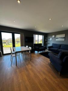 ein Wohnzimmer mit einem Tisch und einem Sofa in der Unterkunft Countryside Chalet near Glasgow in Glasgow