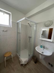 La salle de bains est pourvue d'une douche et d'un lavabo. dans l'établissement Kiskut Liget Pension, à Győr
