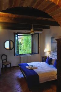 um quarto com uma cama grande e uma janela em Azienda Agricola Tenuta del Barone em Calliano