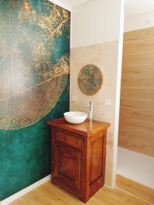 a bathroom with a sink and a large painting on the wall at Bulles de Lune in Sacy