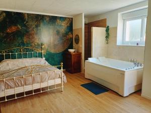 Schlafzimmer mit einem Bett und einer Badewanne in der Unterkunft Bulles de Lune in Sacy