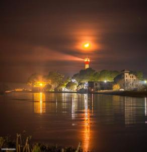 - une vue sur la rivière la nuit avec un phare dans l'établissement Гостевой дом Поти, à Poti