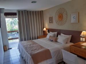 a hotel room with a large bed and a window at Samba Villa da Praia in Salvador