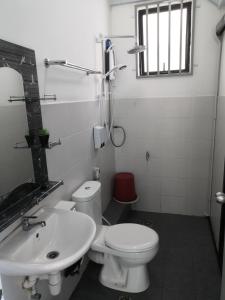 a bathroom with a white toilet and a sink at Hamin De Thor Homestay-Benoni Garden Apartment in Papar
