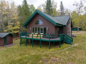 Cabaña de madera con terraza en el patio en Birch Haven home, en Clam Lake