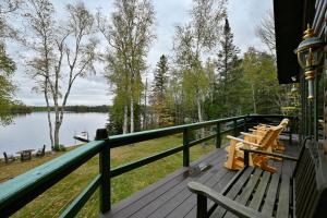 een terras met banken en uitzicht op een meer bij Birch Haven home in Clam Lake