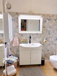 uma casa de banho com um lavatório branco e um espelho. em Mimi Gallery em Budapeste