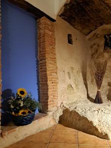 GodojosにあるCASA RURAL LA SOLANAのレンガの柱と花が飾られた窓のある部屋