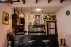 uma cozinha com um balcão preto e bancos em Casamada Residences em Guanajuato